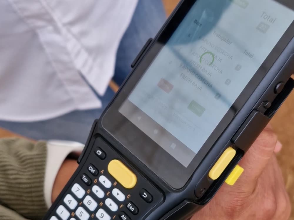 Lector de radiofrecuencia mostrando la pantalla de IntelAgro: bote, trabajador, apoyo cosecha y total